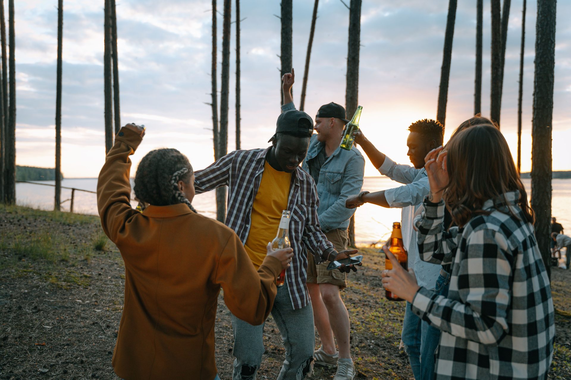 Friends dancing and celebrating at a golden-hour outdoor party