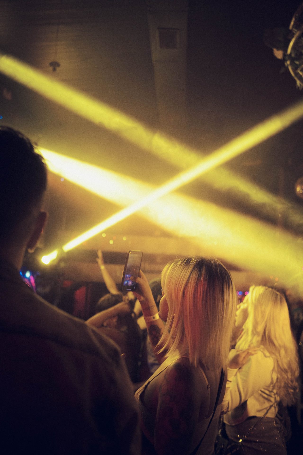 Club crowd under sweeping laser beams